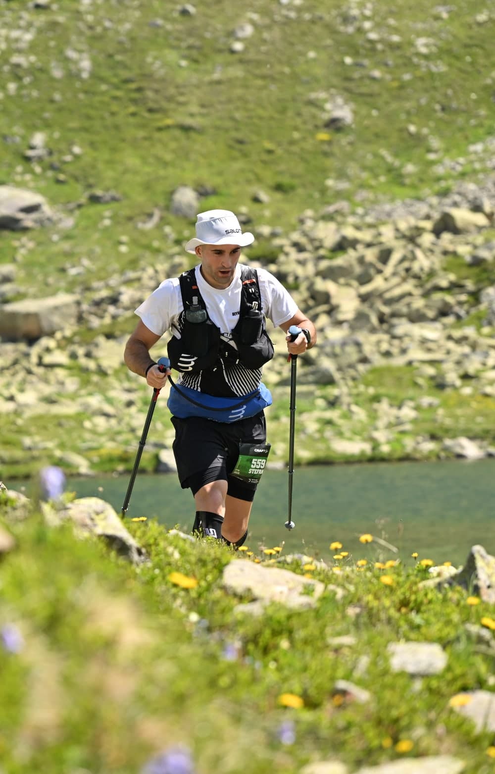 Stefan racing a mountain ultramarathon, climbing a trail above an alpine lake